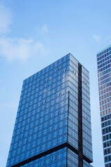 Low angle view of skyscraper with glass window and clear blue sky background for business and...