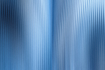 Obraz premium A closeup view of a textured blue surface with vertical ribbed patterns and subtle light reflections, creating an abstract and modern background