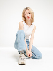 Asian fashion portrait young beautiful cheerful cute woman, blonde short hair wearing white tank...