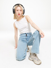 Asian fashion portrait young beautiful cheerful cute woman, blonde short hair wearing headphones...