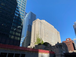 Looking up at the impressive architecture of a towering skyscraper with a distinctive facade and...