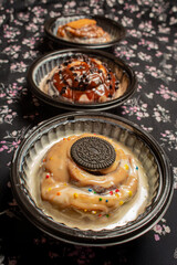 A row of three assorted cinnamon rolls with various sweet toppings