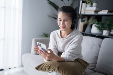 Asian beautiful woman smiling listen music at home in headphones Use technology lifestyle concept