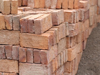 stacked red clay bricks for building material