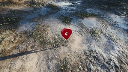 Red location pin on textured ground in outdoor environment  