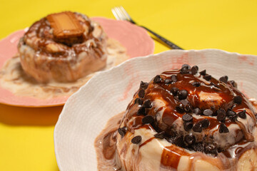 A close up of a gourmet cinnamon roll topped with chocolate chips