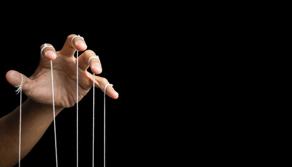 male puppeteer hand with strings isolated on black background. manipulation or controlling concept