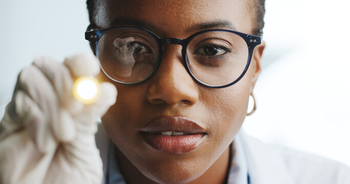 Doctor, woman and check light reflex, eye or pupil for medical response or brain function. African person, healthcare worker or penlight test for nerve reaction, diagnosis or exam POV with portrait