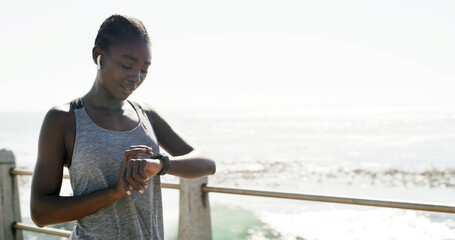 Black woman, fitness and beach with smart watch for performance, step counter or pulse in nature. Active, female person or runner checking wristwatch for workout schedule or heart rate on promenade