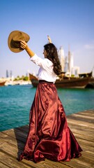 Obraz premium Woman in flowing skirt, enjoying the waterfront