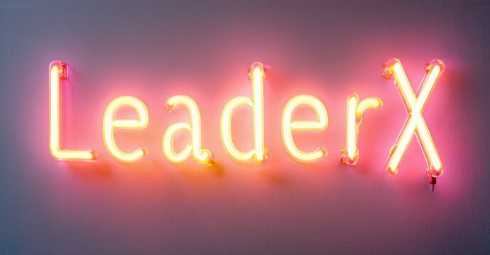 Bright neon sign displays LeaderX. Orange glow illuminates wall. Simple design, modern aesthetic, impactful branding element.