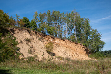 Sandy slope with visible sandstone and clay, partly used by people for small-scale stone and sand...