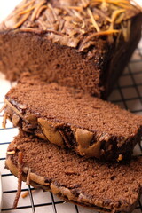 Sliced of chocolate cake. Chocolate brownies sprinkled with cheese on a cooling rack. Sweet cake.