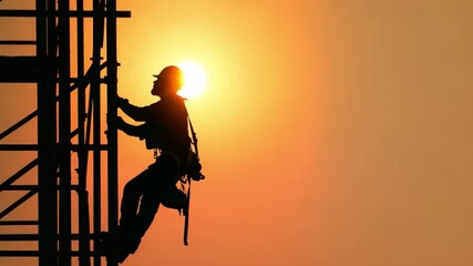 Construction Worker Against the Sunset: A silhouette of a construction worker scaling a scaffolding at sunset, embodying hard work and dedication with warm color and dynamic movement.