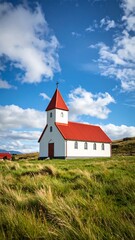 White church with red roof on a grassy hilltop under a partly cloudy blue sky
