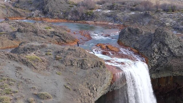 Approaching aerial fly to the Salto del Agrio waterfall top side where flowing the river between rocky environment, Neuquén, Argentina.