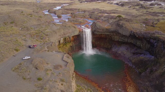 Panoramic aerial fly from striking Salto del Agrio waterfall plunging into the river bay in a rocky Patagonian volcanic canyon, Neuquén, Argentina.