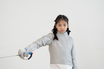 Asian girl in fencing costume and holding sword for practicing and training in gym. Teen girl...