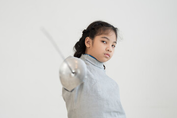 Asian girl in fencing costume and holding sword for practicing and training in gym. Teen girl...