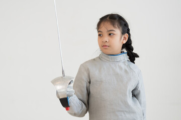 Asian girl in fencing costume and holding sword for practicing and training in gym. Teen girl...