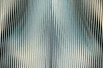 Obraz premium A textured metallic surface with vertical ribbed patterns, featuring a gradient of light and shadow