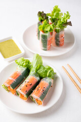 Salad roll with crab stick, carrot, cucumber and lettuce wrapped with rice paper eating with dipping sauce