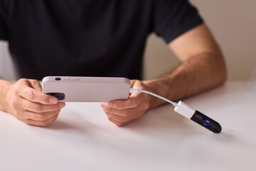 man using otg usb with her mobile phone to copy photos