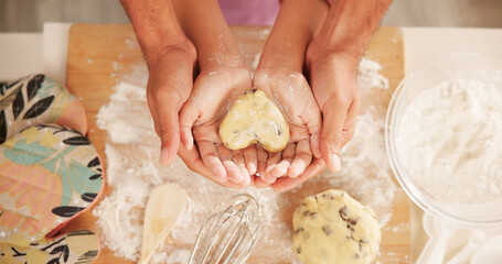 Baking, hands and heart with family in kitchen together for development, learning or recipe from above. Dough, ingredients and shape with parent teaching child how to bake cookies in apartment