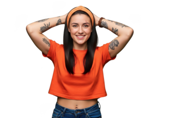 A beautiful young woman with long dark hair and tattoos, wearing an orange shirt and bandana, smiling and holding her hands behind her head, isolated on transparent background