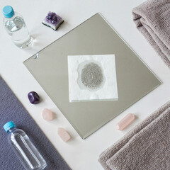 Fogged mirror displaying fingerprint on napkin with wellness items  