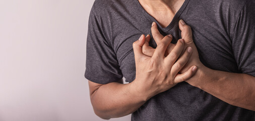 heart disease concept. man pressing on chest with painful expression. severe heartache and having...