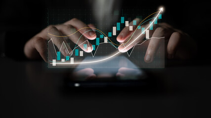 Focused hands interact with a smartphone displaying glowing graphs and analytics, signifying...