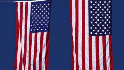 Fototapeta premium Two American Flags Hanging Against a Blue Sky stars and stripes