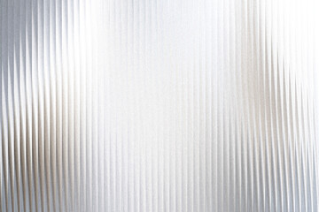 A closeup view of a textured surface with vertical ribbed lines and a shimmering, speckled effect, creating a sense of depth and abstract beauty