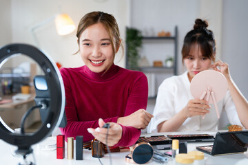 Business online on social media, Two Beautiful Woman Blogger is showing present tutorial beauty cosmetic product and broadcast live streaming video to social network while recording teaching online.