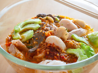 Traditional Thai Tom Yum Noodle Soup with Pork, Meatballs, Dried Shrimp and Pork Liver in Authentic Local Style Street Food Cuisine.