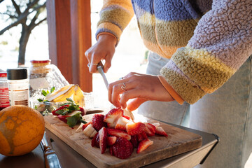 Chef preparing and healthy fruit salad with fresh ingredients outdoors