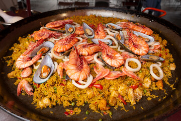 Large pan of paella with fresh seafood, vegetables and rice