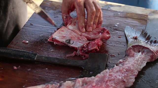 Butchering Bighead Carp on Wooden Board &ndash; Strong Hands at Work