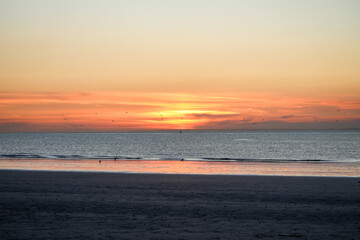 Sunset on the Atlantic coast. Reflections in the water in pastel tones.
