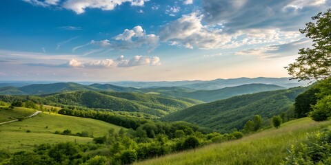 Obraz premium Vibrant green rolling hills under a dramatic sky with wispy clouds and sunlight breaking through
