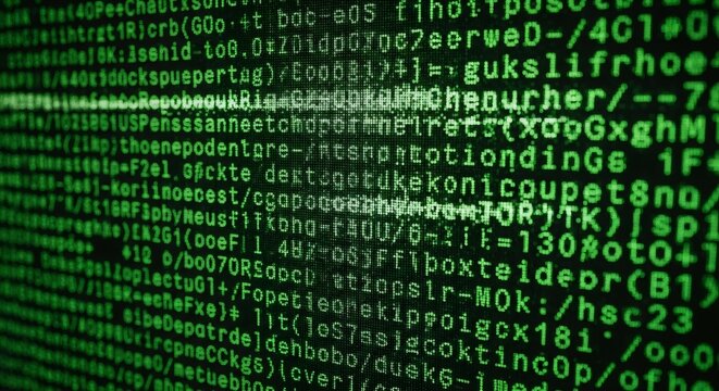 Green glowing digital code on a black screen background. Abstract concept of programming, data, and technology.