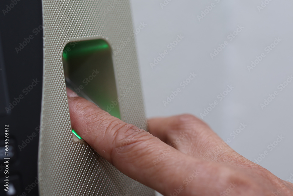 Poster close up view of finger being placed on biometric scanner, showcasing technology used for identifica