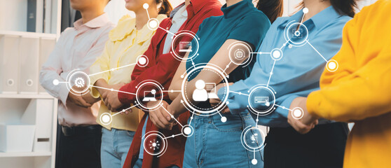 A diverse group of people stands together in a modern office space, showcasing collaboration and innovation through a digital network connection overlay that emphasizes teamwork and engagement. Amity