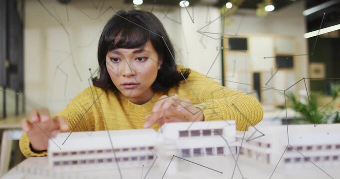 Placing left hand on model and adjusting facade element, architect aligning block for accuracy