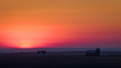 Vibrant sunset over a rural landscape with silhouetted animals