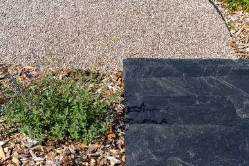 Jardin moderne avec deux escaliers en pierre gris anthracite reliés par un chemin de petits...
