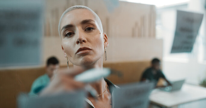 Creative woman, writing and glass wall for planning, brainstorming and sticky notes strategy in office. Business owner, entrepreneur face and mood board for goals, project thinking or proposal