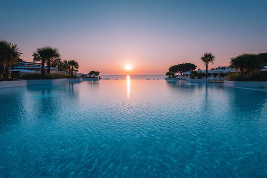 A large pool with a beautiful sunset in the background