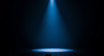 Blue spotlight on stage in dark theater
